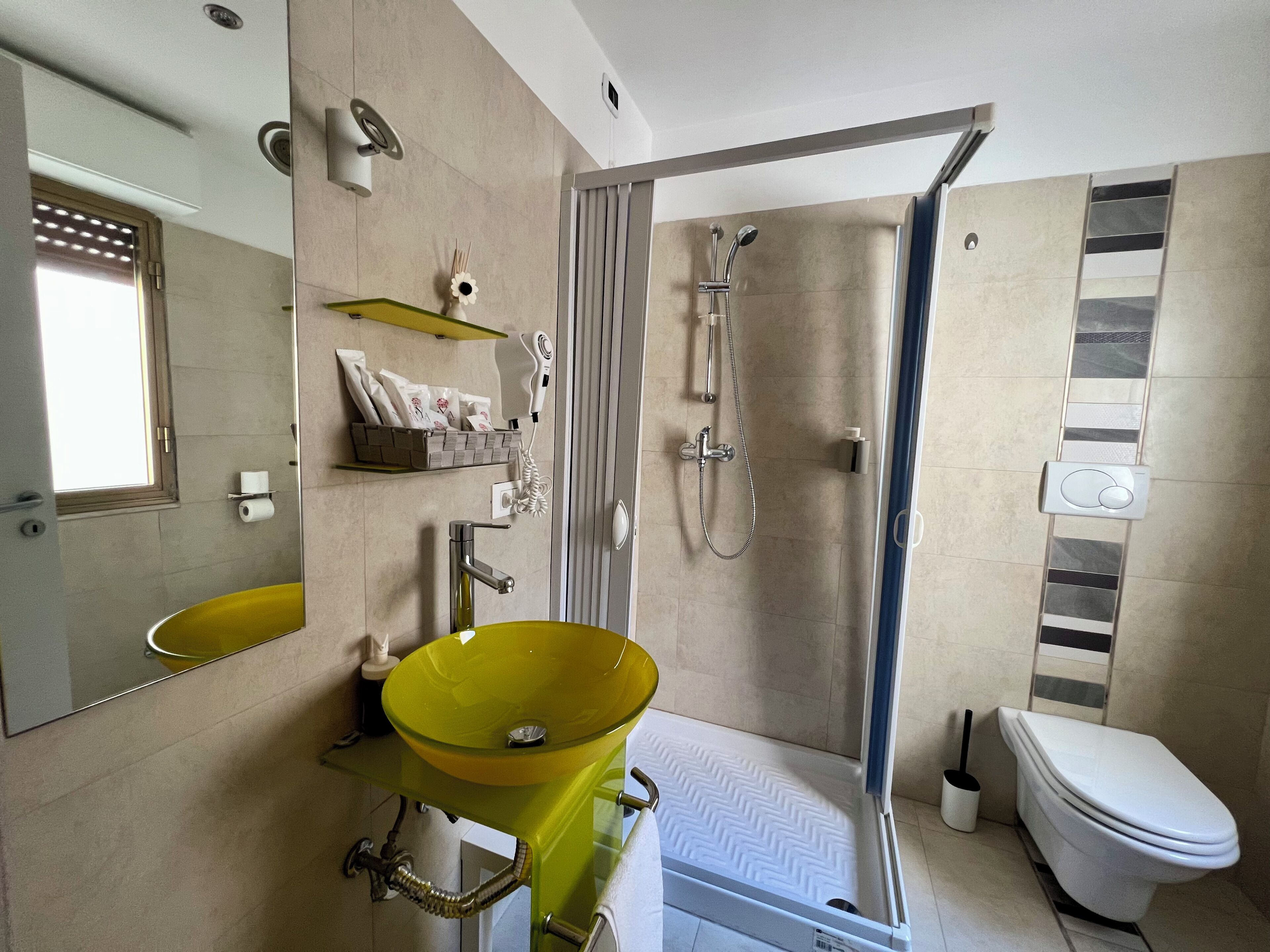 Driepersoonskamer | Badkamer | Een haardroger, handdoeken, zeep, shampoo