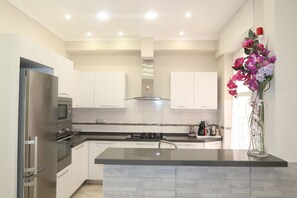 Una cocina moderna con una isla central, electrodomésticos de acero inoxidable y una decoración de orquídeas.