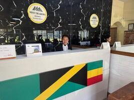 A reception desk with a flag design, a marble wall, and two signs for MISTY MEADOWS RESORTS KASAIHI HILLS.