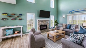 Una sala de estar con chimenea de piedra, televisor de pantalla plana y un conjunto de sofás.
