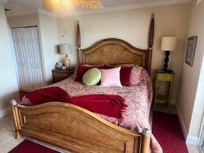 Ein Schlafzimmer mit einem hölzernen Bett, einem Nachttisch, einer Lampe und einer Tür.