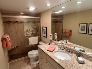 Ein Badezimmer mit Toilette, Waschbecken und Duschbereich.