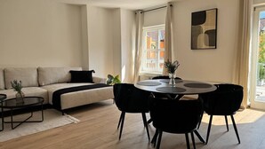 A modern living room with a sofa, coffee table, dining table, and chairs. - Faraway Homes Studio Mautern #8 (Mautern in Steiermark)