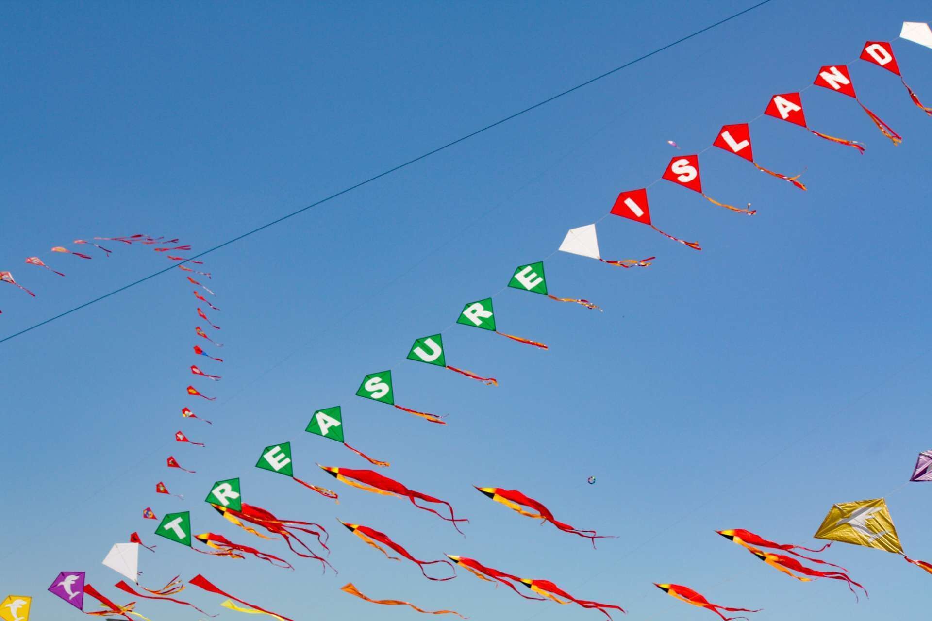 A clear blue sky with numerous kites flying.