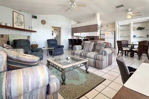 Ein Wohnzimmer mit Sofas, einem Couchtisch und einem Essbereich mit Stühlen und einem Tisch.