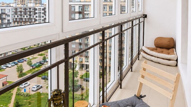A balcony with a table, chairs, and a view of a cityscape. - Modern Apartment with Library View (Minsk)