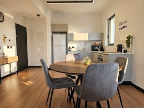 Eine moderne Küche mit Essbereich, einer Uhr und einem Schild mit der Aufschrift 'Kitchen'.
