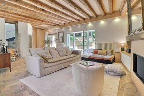 A cozy living room with a sofa, a small table, and a fireplace. - Pierres – A charming home where stone, light, and the good life come togeth (Saint-Cyr-au-Mont-d'Or)