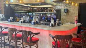 Un espace bar avec un comptoir, des tabourets et des luminaires suspendus.