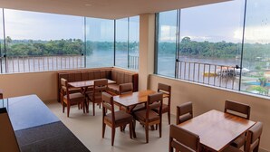 A restaurant with large windows offering a view of a river and greenery. - Hotel Madalena - Beiro Rio (Sao Miguel Do Guama)
