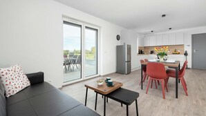 Un apartamento moderno con comedor, cocina y un sofá con vistas.