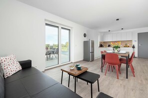 Eine moderne Wohnung mit Essbereich, Küche und einer Couch mit Blick.