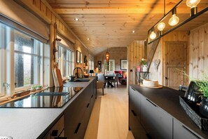 Una cucina moderna con pareti in legno, un'isola centrale e luci a sospensione.