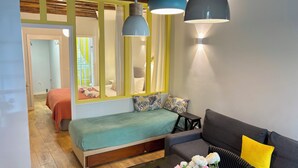 A modern room with a bed, a sofa, a coffee table with flowers, and a mirror. - Odéon Saint Germain - Central Flat Aldaro (Paris)