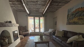 Una sala de estar con chimenea, un sofá, una mesa de centro y un cuadro en la pared.