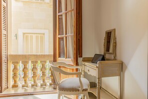 A room with a wooden chair, a desk, and a window with shutters. - Casa Angels with private pool in the historic center of Pollença (Pollensa)