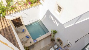 A rooftop pool with a view of the city, surrounded by potted plants and outdoor furniture. - Casa Angels with private pool in the historic center of Pollença (Pollensa)