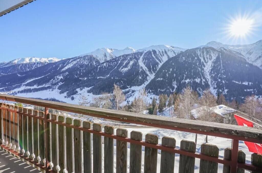A mountain landscape with snow-covered peaks and a clear sky.