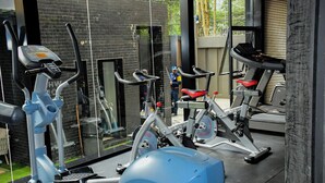 A gym with exercise equipment, a glass wall, and a brick wall. - Clean, cozy and welcoming space for all my guests. (Nairobi)