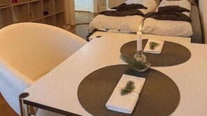 Ein modernes Schlafzimmer mit einem Bett, Nachttischen, einem Sessel und einem Bücherregal.