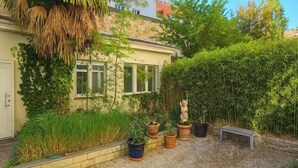 A garden with potted plants, a statue, and a bench.