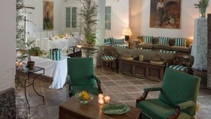 A cozy interior with a dining area, a sofa set, and a painting on the wall. - Private Andalusian Estate for Groups Retreats (Cazalla De La Sierra)