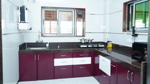 A kitchen with a window, a stove, a sink, and cabinets.
