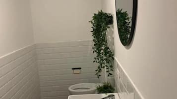 Driepersoonskamer, terras, uitzicht op tuin | Badkamer | Gratis toiletartikelen, een haardroger, handdoeken, zeep