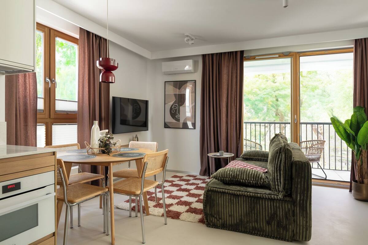 Una cocina moderna con comedor, sofá y balcón con vistas.