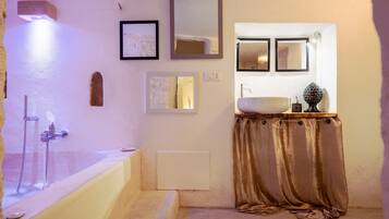 Un bagno con vasca, lavandino, specchio e doccia.