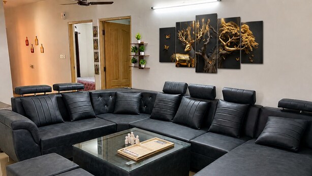 A modern living room with a sectional sofa, glass coffee table, and wall art. - Cozy 2 & 1 Bedroom Apartment in Sahibzada Ajit Singh Nagar (Mohali)