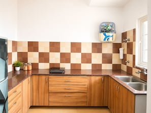 A kitchen with wooden cabinets, a built-in stove, a sink, and a tiled backsplash.