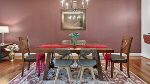 A dining area with a wooden table, chairs, a chandelier, and a mirror on the wall. - Sauna, Free Dollywood & More, Views! - (Gatlinburg)