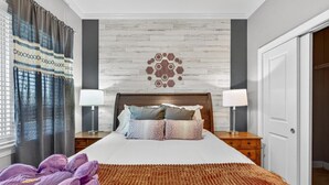 A hotel room with a bed, two bedside tables with lamps, a patterned wall, and a door. - Sauna, Free Dollywood & More, Views! - (Gatlinburg)