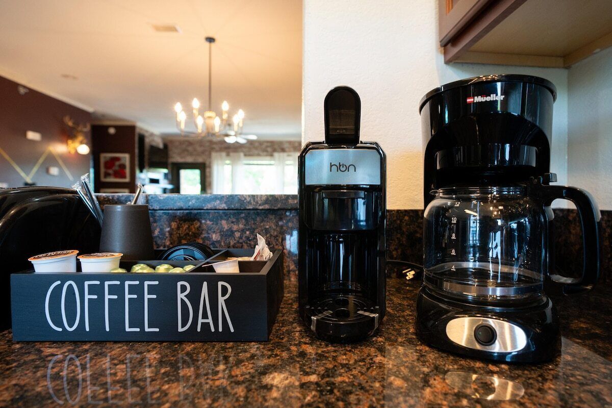 Un espace café équipé d'une machine à café, d'une cafetière à filtre et d'un porte-tasse.