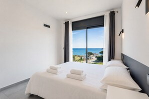 Ein Hotelzimmer mit einem großen Bett, Meerblick und modernem Design.
