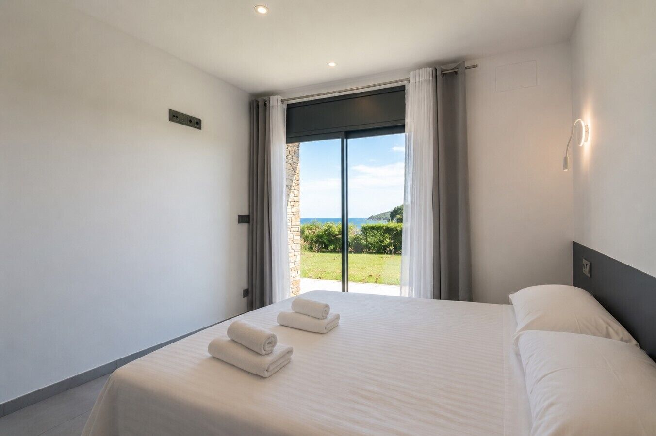 Ein Hotelzimmer mit Bett, Blick ins Freie und einem Vorhangfenster.