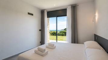 Ein Hotelzimmer mit Bett, Blick ins Freie und einem Vorhangfenster.