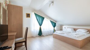 A bedroom with a bed, a desk, a chair, a television, and a picture on the wall. - FarawayHomes Aparthotel Vienna Airport #10 (Bruck an der Leitha)