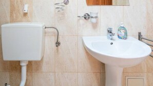 A bathroom with a toilet, sink, and mirror. - FarawayHomes Aparthotel Vienna Airport #10 (Bruck an der Leitha)