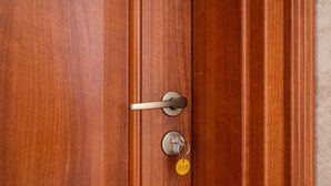 A wooden door with a keyhole and a keyring with a key. - FarawayHomes Aparthotel Vienna Airport #10 (Bruck an der Leitha)