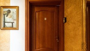 A wooden door with a number plate, a framed painting, and a textured wall. - FarawayHomes Aparthotel Vienna Airport #1 (Bruck an der Leitha)