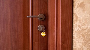 Een houten deur met een sleutelgat en een sleutelhanger met een sleutel.