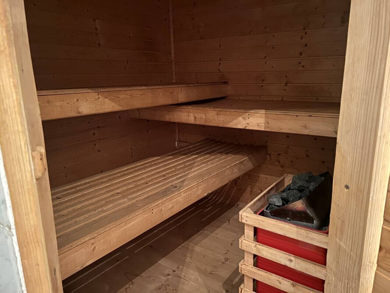 Un intérieur en bois avec des étagères et un meuble de rangement rouge.