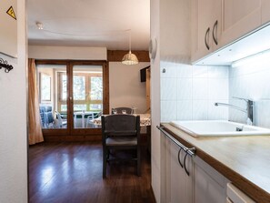 Eine Küche mit Spüle, Schränken und einem Essbereich mit Stühlen und Tisch.