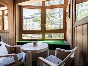 Eine Holzhütte mit Fensterbank, einem kleinen Tisch und zwei Stühlen.