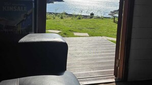 A room with a view of the sea, a poster on the wall, and a leather sofa. - Two Pod Glamping Retreat in Kinsale, Sea Views (Kinsale)