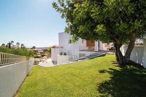 Ein modernes, weißes Gebäude mit Treppe, Baum und Blick auf die Umgebung.