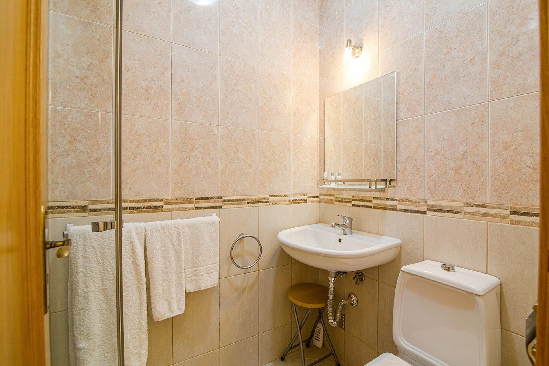 Un baño con lavamanos, inodoro y espejo.