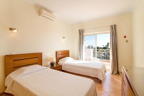 Ein Hotelzimmer mit zwei Betten, einem Balkon und Blick auf die Stadt.